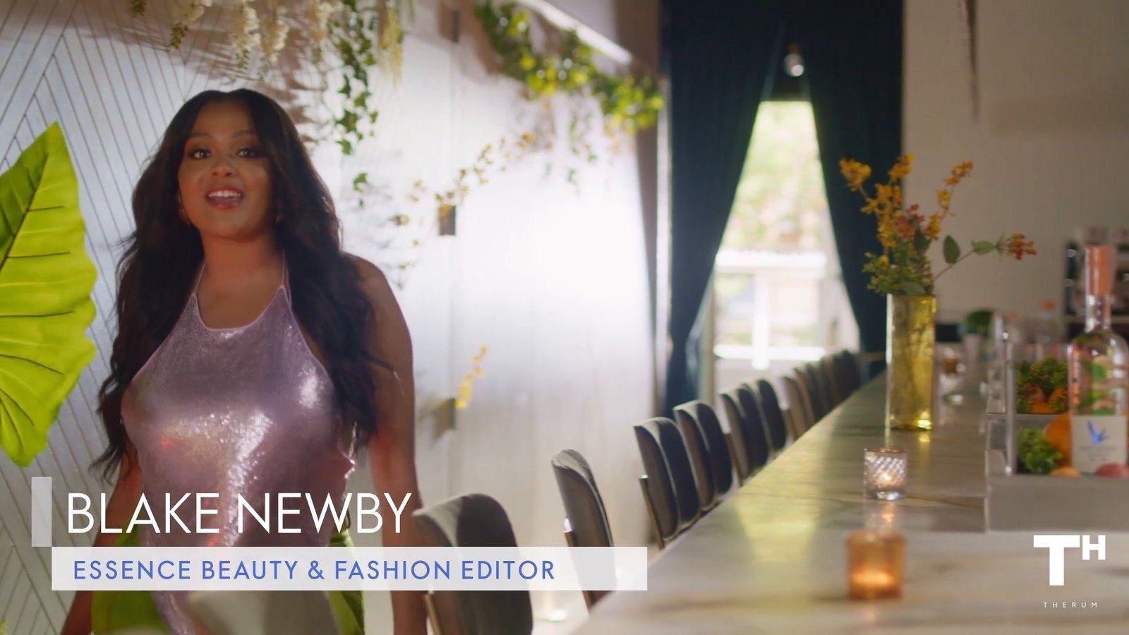 Frame from the final video: Blake Newby’s lower third, Essence Beauty & Fashion Editor, at a long dining table