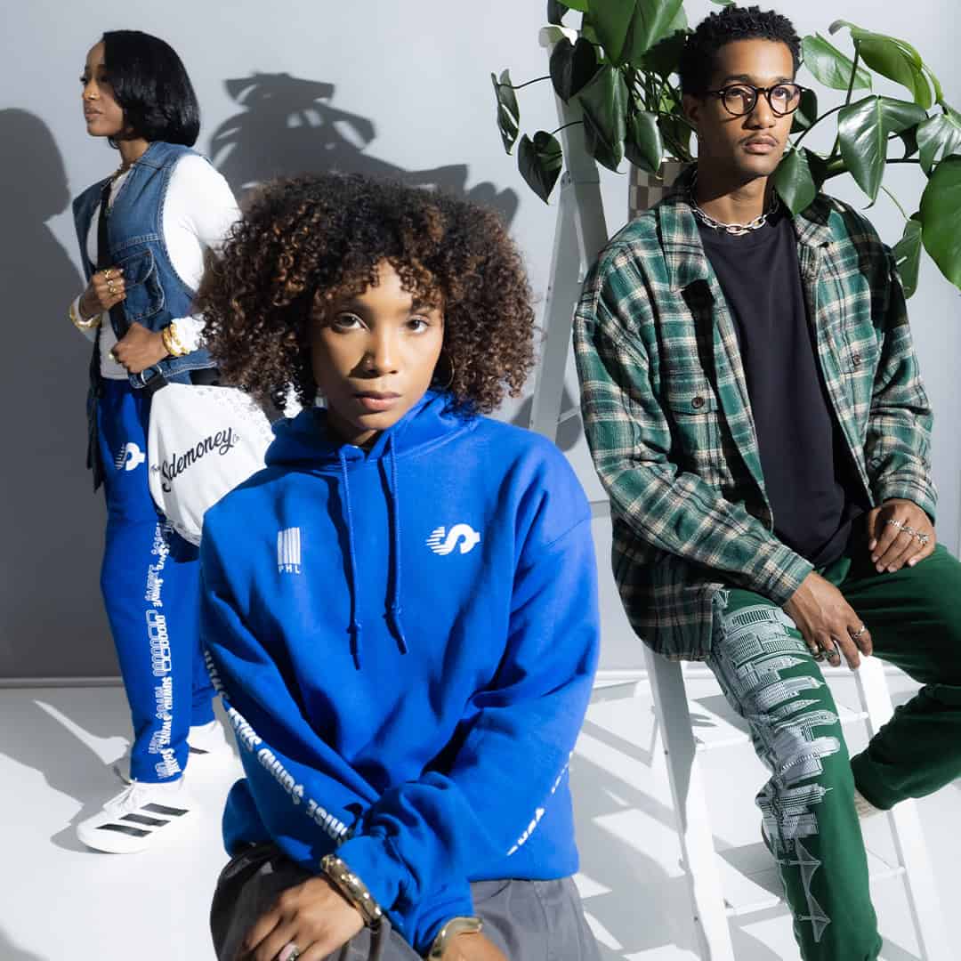 Three models in Sidemoney tracksuits, hoodies and flannel
