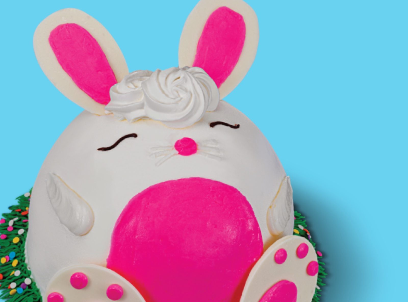 Easter bunny ice cream cake, white with pink ears and nose, photographed on a blue background