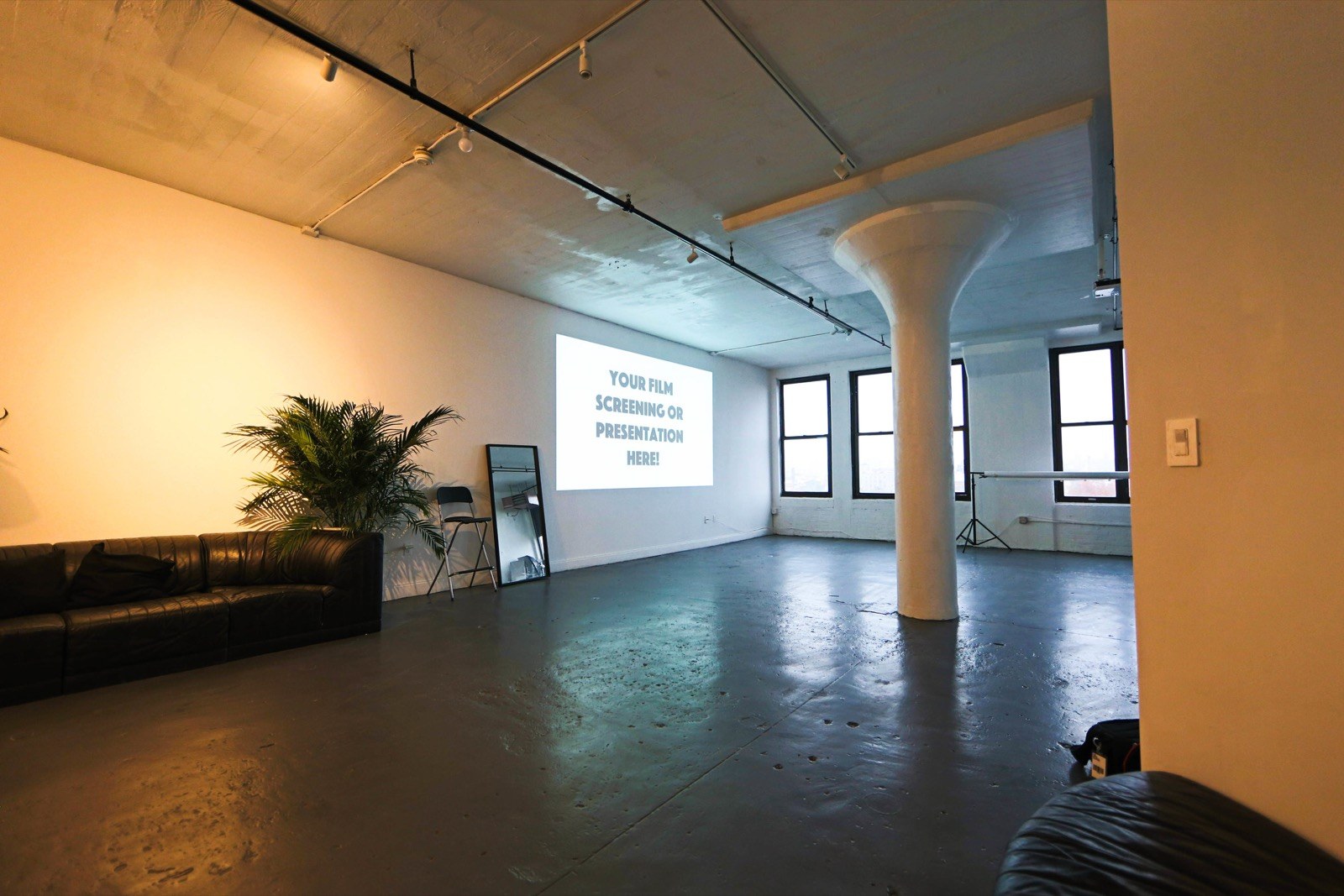 The loft set up for a screening, a projected slide on the far wall