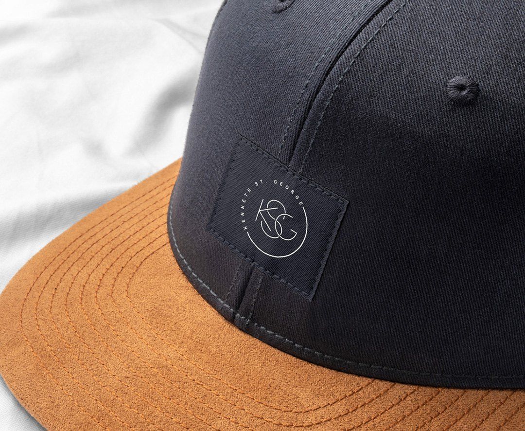 Navy cap with suede brim carrying the KSG mark
