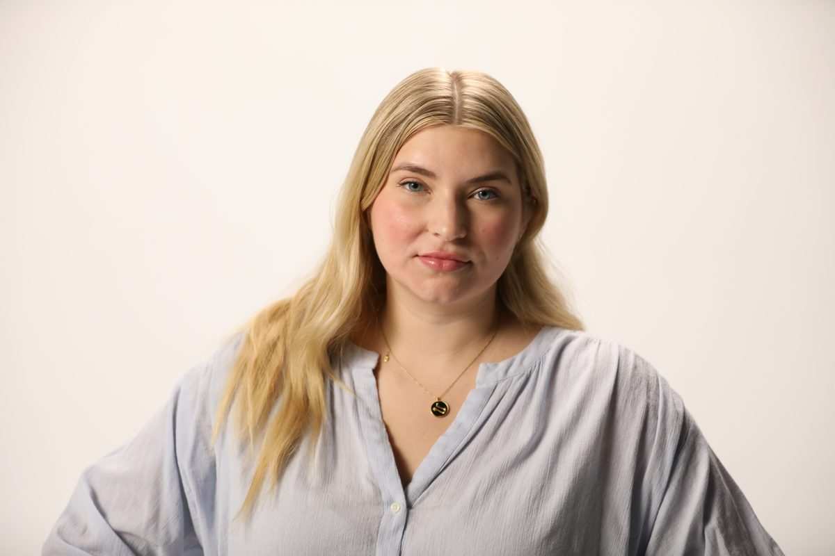 A woman with long blonde hair in a pale blue blouse, from the LetsGetChecked photoshoot