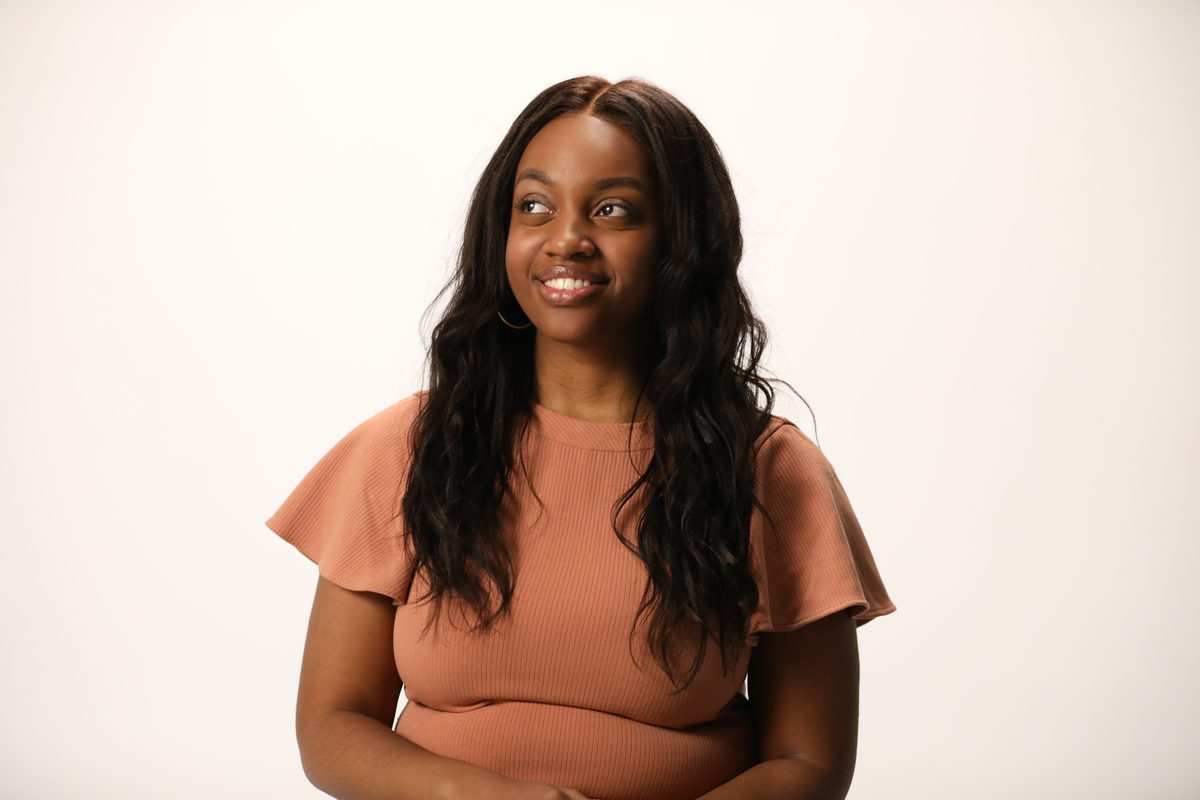 A smiling woman with long dark hair in a terracotta top, from the LetsGetChecked photoshoot